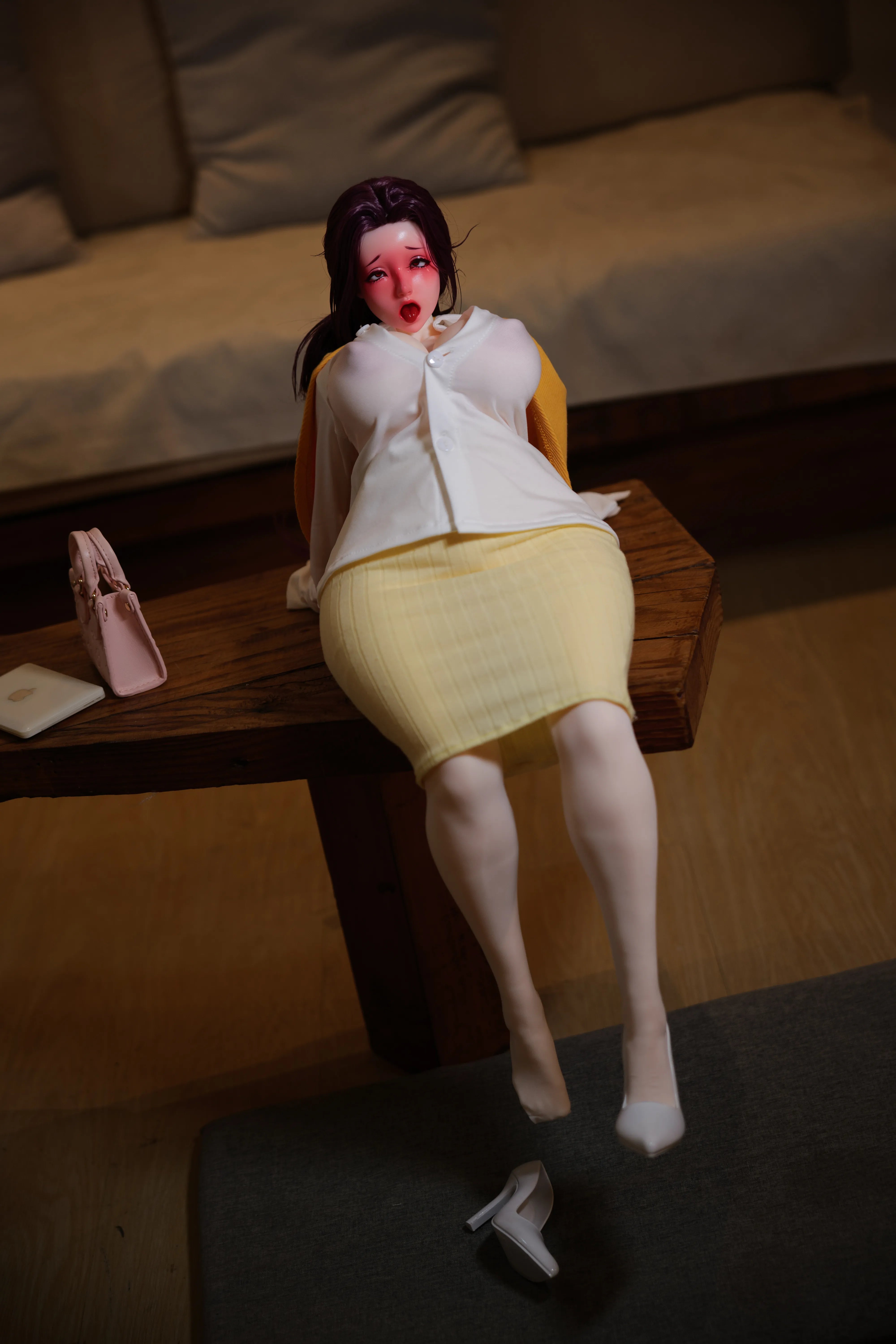 The Aunt Niimi sex doll with an 'Orgasm Face', lying down with her shirt open to reveal her nude torso.